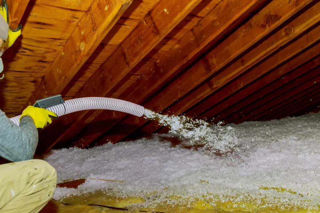Technician blowing loose-fill insulation into an attic in the Rio Grande Valley