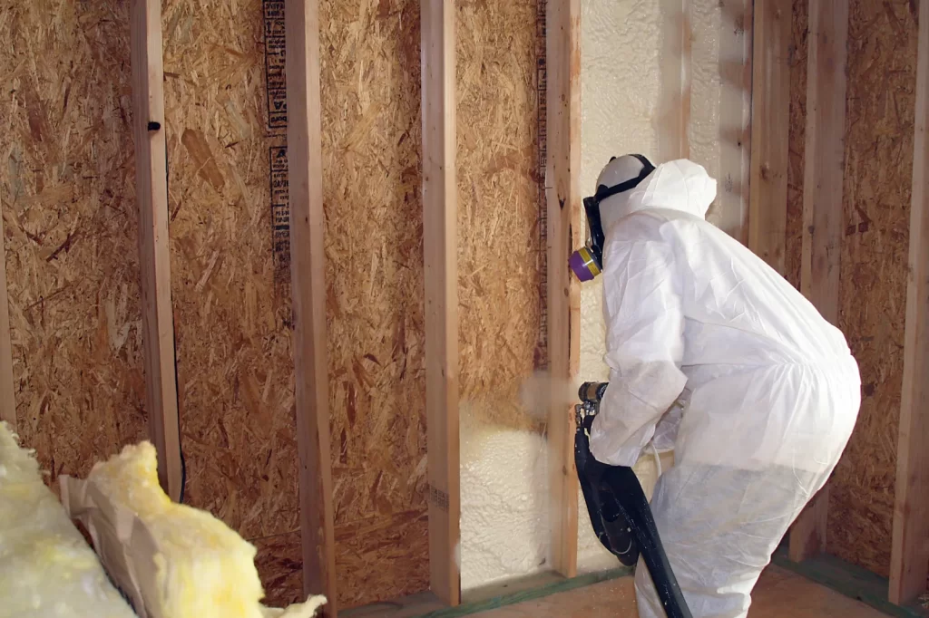 Installer spraying foam into wall cavities in a new Edinburg home